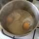 Duck eggs are poured in to poaching water.
