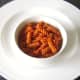 Fusilli pasta and sweet pepper and tomato sauce is spooned in to a serving bowl