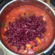 Red kidney beans are added to partly cooked chilli