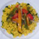 Peppers and onion are spooned on to turmeric rice