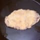Breaded pheasant breast is added to hot frying pan