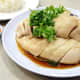 Singaporean-style chicken rice is served with roasted or steamed chicken. The rice itself is lightly flavored. Accompanying chili sauce typically includes garlic too.