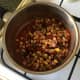 Beans are added to simmering tomato sauce