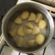 Chopped potatoes are added to cold salted water and put on to reach a boil