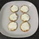 Cream cheese is spread on crackers