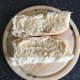 Horseradish sauce is spread on opened sub roll