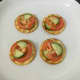 Tomato and cucumber slices are arranged on crackers