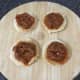 Red pesto is spread on toast circles