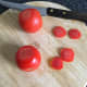 A thin slice is taken from both sides of each tomato