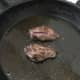 Pigeon breast fillets are turned to fry on second side