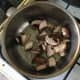 Chopped mushrooms and garlic are added to hot oil