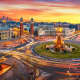 Long exposure photo of Fira de Barcelona, Plaça d'espanya (Spain square) and montjuic mountain in Barcelona at sunset with car light trails . Spain