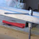 A chainsaw tool will do the trick. A ratchet and socket may be too difficult to work in and out of the metal fold.