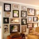 Here's an example of not sticking with the traditional "hang pictures (only) at eye level" thinking - I think this photo wall is dramatic and exciting. I love it!