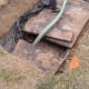 Hose from pump truck gets put into the inlet end first; and yes, that brown 'background' beneath the hose is raw sewage showing just below the top of the tank!