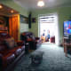 Living room with old net curtain hung and drawn opened on the right of the French doors.