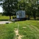 Our shed is being delivered. You can see the stone pad and the stack of 2" pavers, ready in case the driver needs them to level the building.