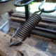 Spring reattached to the chair; having made a new loop by pulling out the end of one of the coils from the spring.