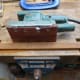 Using an electric sander to round the edges of the front stretcher to closely match the stretchers in the other chairs.