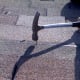 The upper shingle (bottom of photo) is curled up, revealing the nailing area. The nail is placed on the tar line and driven through both the new shingle and the older shingle underneath it.