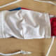 I stretched a strip of t-shirt fabric to make a cord then, using a safety pin, brought the cord up from the bottom of one side, then down through the top of the other side. Alternatively, two smaller cords could be cut to make 2 ties.