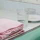 Take your stuff into a thoroughly cleaned bathroom, or use a sink that is easy to bend over and has been well sanitized. Make sure you have some washcloths nearby. Fill one of your glasses with cool water.