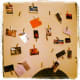 Clothes pegs attached to the wall in a random pattern hold the cards in place. From Flickr: http://www.flickr.com/photos/silv3rglee/6760497037