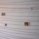 A low cost but effective method. Just criss cross a wall with yarn and attach pictures. From flickr: http://www.flickr.com/photos/orinrobertjohn/139788703