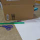 Get your craft supplies ready. We used a piece of cardboard box, some large white paper, scissors, and a pencil. Simple!