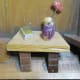 Vase on table, fabric flower, wire stem, painted, clay vase, book, table legs.