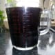 The collected essential eucalyptus oil is transferred to a measuring jug.