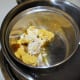 Create a double boiler with the two pots to melt the butters and wax.