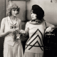 Joyce Compton and Clara Bow with longer curly bobs.