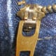 Close up of a genuine YKK zipper fastener. The YKK lettering could appear on both front & rear of the slider hardware
