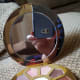 The compact features a full-sized mirror inside, along with ten eye shadows and a white highlight shade in the middle.