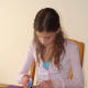 Olivia glues down her pictures.