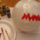 Fit shower cap over balloon and paint face.