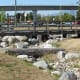 A log bridge in a playground: the channel is filled with water for part of the year