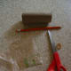 A cardboard tube, pencil, rubber band, and grocery bag are required to make this kazoo.