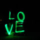 Taking a picture while spelling "love" with glow sticks.