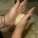 Firmly roll dough ball somewhat flat to press out extra air by moving your hands over dough ball while smoothing the surface.
