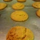 Baked raisin molasses sugar cookies still on a greased cookie sheet.