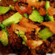 Tomatoes and avocadoes on top of beans and rice.