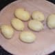 Cooled and peeled potatoes ready for deep frying