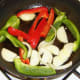 Chopped vegetables are added to frying pan