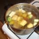 Vegetables and stock are added to browned oxtail.