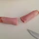 5. Roll one piece of deli meat up and slice in half.