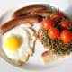 Fried egg is laid on the vacant part of the plate and the tomatoes are simply lifted on to the laver cake.