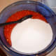 Pour two cups of mashed strawberries and four cups of sugar in a bowl and stir. It's important to be as close to accurate as possible.