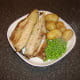 Potatoes and peas are plated alongside the Arbroath smokie